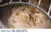 Spiral kneader kneads fresh dough for baking in bakery. Стоковое фото, фотограф David Kashakhi / Фотобанк Лори