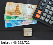 Российские деньги, калькулятор лежат на черном офисном портфеле. Стоковое фото, фотограф Цибаев Алексей / Фотобанк Лори