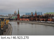 Moscow, Russia, 12.31.2024: Vodovzvodnaya, Blagoveshchenskaya and Borovitskaya towers on the Kremlin embankment of the Moskva River and Moscow City Business Center in the background on a winter day. Редакционное фото, фотограф Ula Ulachka / Фотобанк Лори