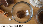 Close up top view of a woman hand putting granulated instant coffee, sugar, and hot water into the mug. Стоковое фото, фотограф David Kashakhi / Фотобанк Лори