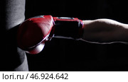 Fighter Practicing Some Kicks With Punching Bag - A Man With A Tattoo Boxing On dark Background. Стоковое фото, фотограф David Kashakhi / Фотобанк Лори