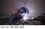 Welding worker works on metal structure in factory. Стоковое фото, фотограф David Kashakhi / Фотобанк Лори