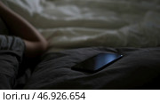 Guy sleeping at night with his smartphone lying near on a blanket at home. Стоковое фото, фотограф David Kashakhi / Фотобанк Лори