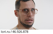Man in glasses cringes with embarrassment at awkward moment. Стоковое видео, видеограф Илья Шаматура / Фотобанк Лори