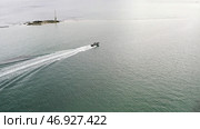 Aerial view of white motorboat and red water biking sailing on the sea or river in sunny day. Стоковое фото, фотограф David Kashakhi / Фотобанк Лори
