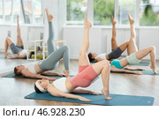 Girls at group Hatha yoga class does preliminary preparatory stretching. Стоковое фото, фотограф Яков Филимонов / Фотобанк Лори