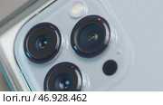 RUSSIA, MOSCOW - SEPTEMBER 27, 2021: Close-up of three cameras in iPhone. Редакционное фото, фотограф David Kashakhi / Фотобанк Лори