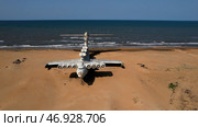 Aerial view of a ruined abandoned airplane found in an uninhabited island near the sea on blue sky background. Стоковое фото, фотограф David Kashakhi / Фотобанк Лори