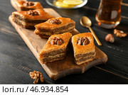 Доска с вкусной пахлавой на фоне темного дерева. Стоковое фото, фотограф Pixel_shot / Фотобанк Лори