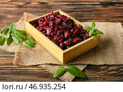 Коробка с вкусной сушеной клюквой на деревянном фоне. Стоковое фото, фотограф Pixel_shot / Фотобанк Лори