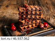 Доска вкусных шоколадных бельгийских вафель с вишней на деревянном фоне. Стоковое фото, фотограф Pixel_shot / Фотобанк Лори