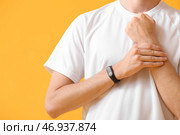 Спортивный бегун проверяет пульс на цветном фоне. Стоковое фото, фотограф Pixel_shot / Фотобанк Лори