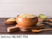 Чаша с вкусным кускусом на деревянном фоне. Стоковое фото, фотограф Pixel_shot / Фотобанк Лори