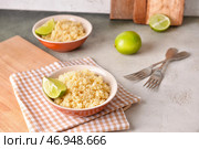Чаши с вкусным кус-кусом и лаймом на столе. Стоковое фото, фотограф Pixel_shot / Фотобанк Лори