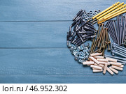 Различные гайки, болты, шурупы, дюбели, гвозди и мебельные уголки на цветном деревянном фоне. Стоковое фото, фотограф Pixel_shot / Фотобанк Лори