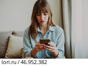 Sad woman after losing money to phone scammers, victim of phone fraud, financial loss, emotional distress, smartphone, scam warning, worried expression, scam incident. Стоковое AI-изображение, AI-художник Павел Муравьев / Фотобанк Лори