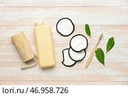 Многоразовые ватные диски, мочалка и бутылка с гелем для душа на светлом деревянном фоне. Стоковое фото, фотограф Pixel_shot / Фотобанк Лори