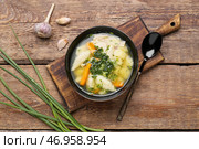 Композиция с тарелкой вкусного супа с клецками, зеленым луком и чесноком на деревянном фоне. Стоковое фото, фотограф Pixel_shot / Фотобанк Лори