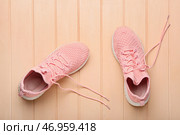Спортивная обувь с развязанными шнурками на цветном деревянном фоне. Стоковое фото, фотограф Pixel_shot / Фотобанк Лори