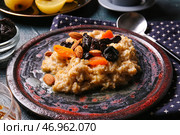 Тарелка со сладкой овсянкой, черносливом, курагой и миндальными орехами на столе, крупным планом. Стоковое фото, фотограф Pixel_shot / Фотобанк Лори