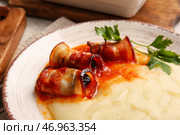 Тарелка с картофельным пюре, вкуснейшим соусом и черносливом в беконе, крупным планом. Стоковое фото, фотограф Pixel_shot / Фотобанк Лори