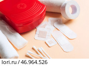Аптечка с медицинскими пластырями, эластичным бинтом и ватными палочками на цветном фоне, крупным планом. Стоковое фото, фотограф Pixel_shot / Фотобанк Лори