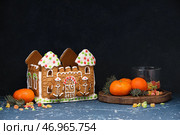 Пряничный домик и мандарины на столе. Стоковое фото, фотограф Pixel_shot / Фотобанк Лори