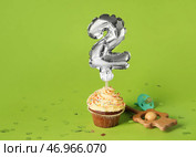 Вкусный кекс на день рождения с детской погремушкой и соской на цветном фоне. Стоковое фото, фотограф Pixel_shot / Фотобанк Лори