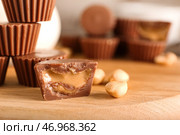 Доска с вкусными шоколадными конфетами с арахисовым маслом на деревянном фоне, крупным планом. Стоковое фото, фотограф Pixel_shot / Фотобанк Лори