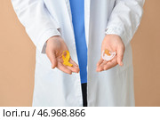 Женщина-врач держит соску и золотую ленту осознания на цветном фоне. Международный день защиты от рака. Стоковое фото, фотограф Pixel_shot / Фотобанк Лори