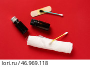 Флаконы с йодом, медицинский пластырь, ватный тампон и марлевый валик на красном фоне. Стоковое фото, фотограф Pixel_shot / Фотобанк Лори