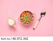 Чаша с хрустящими зерновыми кольцами, ложкой и молоком на цветном фоне. Стоковое фото, фотограф Pixel_shot / Фотобанк Лори