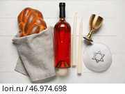 Традиционный хлеб халы с бутылкой вина, свечами и еврейской кепкой на белом деревянном фоне. Шаббат Шалом. Стоковое фото, фотограф Pixel_shot / Фотобанк Лори