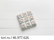 Игра крестики-нолики на белом деревянном фоне. Стоковое фото, фотограф Pixel_shot / Фотобанк Лори