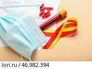Лента осведомленности с таблетками, образцом крови и медицинской маской на бежевом фоне, крупным планом. Концепция гепатита. Стоковое фото, фотограф Pixel_shot / Фотобанк Лори
