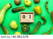 Деревянный кубический календарь с датой 1 НОЯБРЯ и свежими продуктами на зеленом фоне. Концепция Всемирного дня вегана. Стоковое фото, фотограф Pixel_shot / Фотобанк Лори