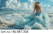 Elegant woman in flowing blue made of waves dress standing by the ocean waves.Элегантная женщина в струящемся голубом платье из волн стоит у океанских волн.  Женщина в струящемся голубом платье грациозно стоит у кромки океана, ее волосы развеваются на ветру. Небо затянуто облаками, что усиливает спокойную атмосферу. Стоковое AI-изображение, AI-художник Katsiaryna Repich / Фотобанк Лори