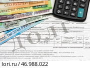 Долговая квитанция на оплату коммунальных услуг за электричество, купюры и калькулятор. Редакционное фото, фотограф Игорь Низов / Фотобанк Лори