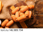 Доска вкусных отварных сосисок на деревянном фоне. Стоковое фото, фотограф Pixel_shot / Фотобанк Лори