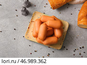 Тарелка вкусных отварных колбасок и багет на сером столе. Стоковое фото, фотограф Pixel_shot / Фотобанк Лори