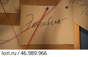 Mysterious word in rebus from notes on board with red thread. Стоковое фото, фотограф David Kashakhi / Фотобанк Лори