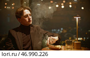 Attractive young man smokes cigar cinematically. Стоковое фото, фотограф David Kashakhi / Фотобанк Лори