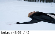 Happy young man in fairytale winter forest lying on snow. Стоковое фото, фотограф David Kashakhi / Фотобанк Лори