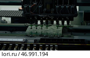 Automatic pick and place machine is installing components on circuit board. Стоковое фото, фотограф David Kashakhi / Фотобанк Лори