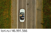 Aerial view of convertible car driving along country road in forest of Georgia in summer on sunny day. Стоковое фото, фотограф David Kashakhi / Фотобанк Лори