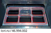 Close up of automatic machine for making plastic containers. Стоковое фото, фотограф David Kashakhi / Фотобанк Лори