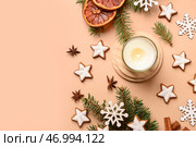 Звездообразное имбирное печенье с ветками ели и горящей свечой на коричневом фоне. Стоковое фото, фотограф Pixel_shot / Фотобанк Лори