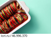 Форма для выпечки вкусного рагу из овощей на бирюзовом фоне. Стоковое фото, фотограф Pixel_shot / Фотобанк Лори