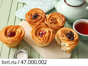 Доска с вкусными краффинами и чашка чая на зеленом деревянном фоне. Стоковое фото, фотограф Pixel_shot / Фотобанк Лори