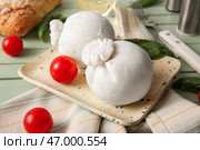 Тарелка вкусного сыра Буррата с базиликом и помидорами на зеленом деревянном фоне. Стоковое фото, фотограф Pixel_shot / Фотобанк Лори